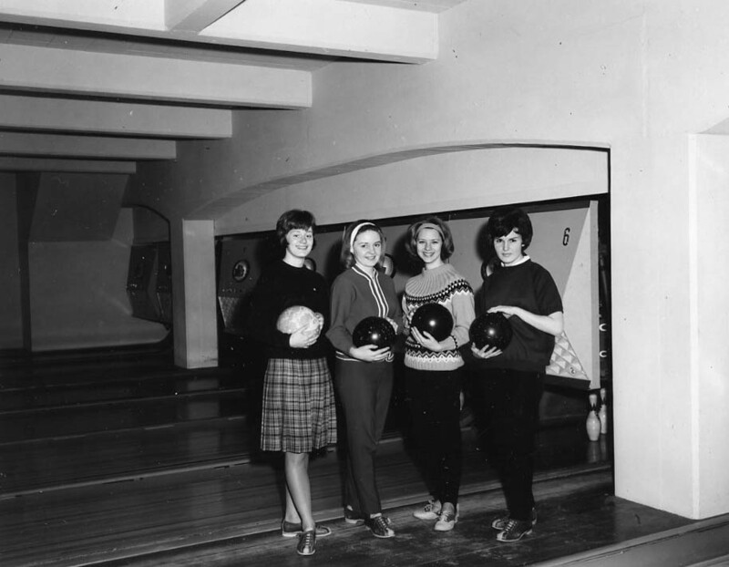 Sherie Gauthier, Karen Johnson, Barbara Weeks, and Karen Collins standing together holding bowling balls for photo