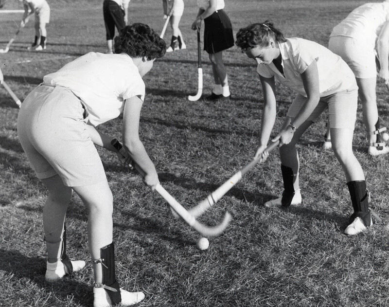 Denise Darwin and Brenda Lazelle playing field hockey