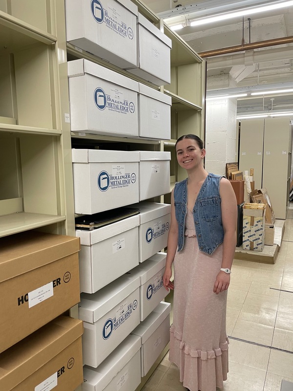 Erin Geslani standing next to a collection of boxes that she processed