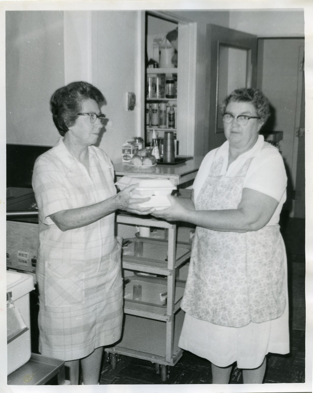 Two women holding packed meals