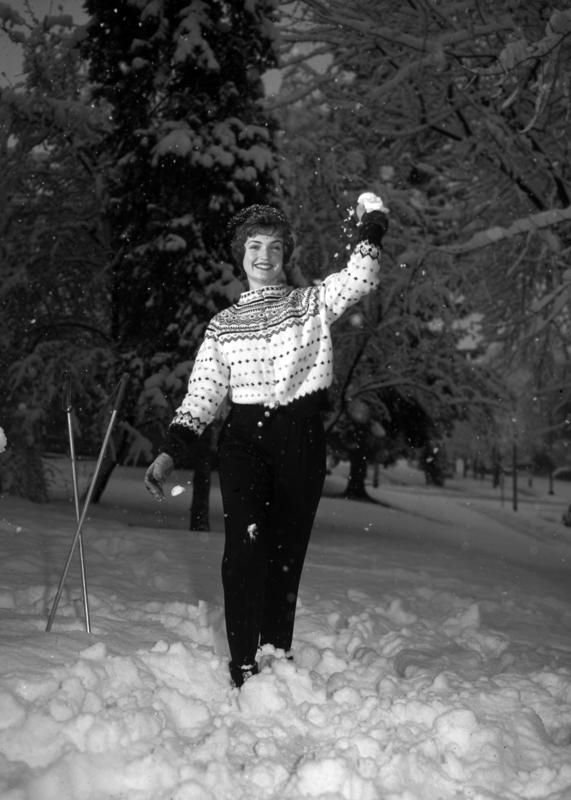 student throwing snow balls and holding ski poles