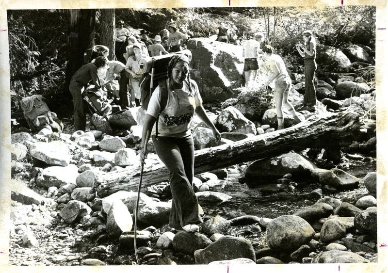 woman walking across riverbed, possibly part of school field trip