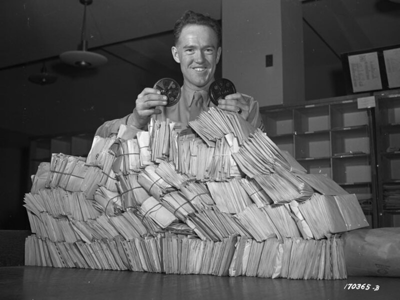 A soldier displays V-Mail film reels and its corresponding number of letters.